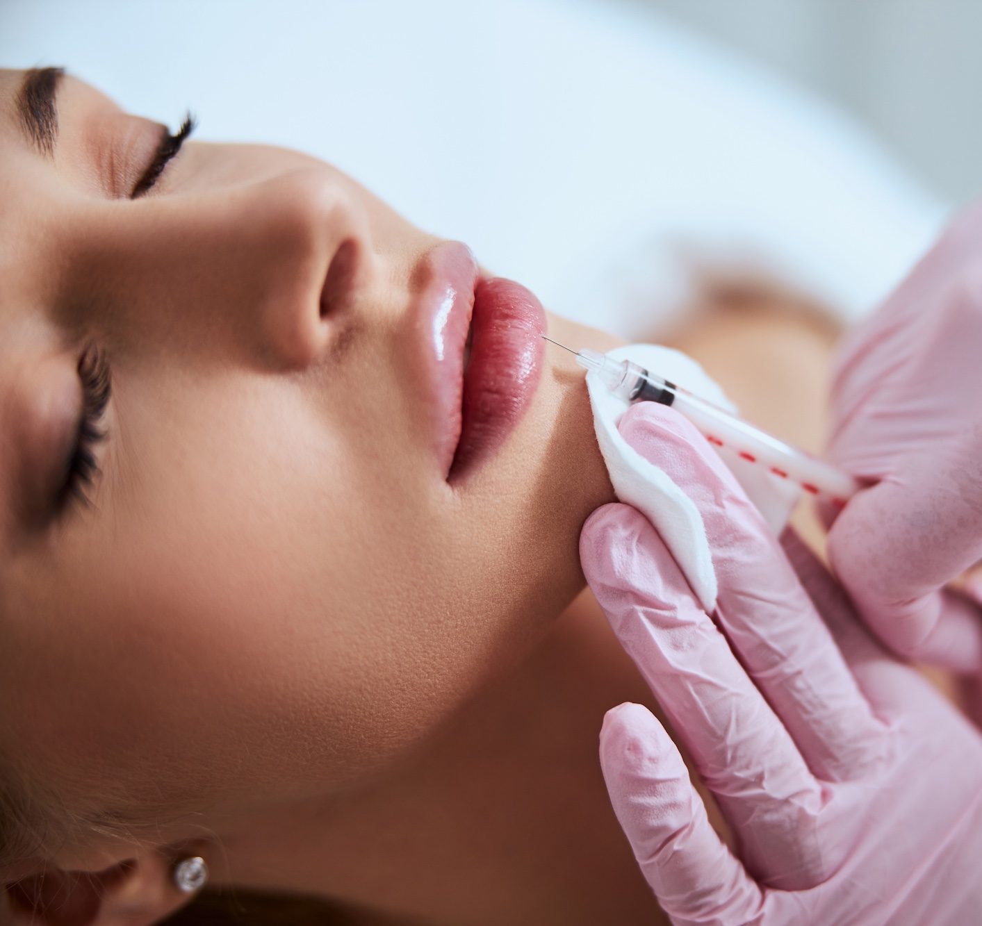 Cosmetic lip filler injection for a woman in a spa treatment close-up