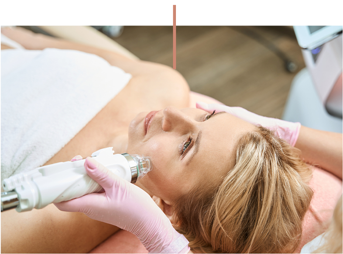 Woman receiving facial skin treatment with handheld aesthetic device in spa clinic