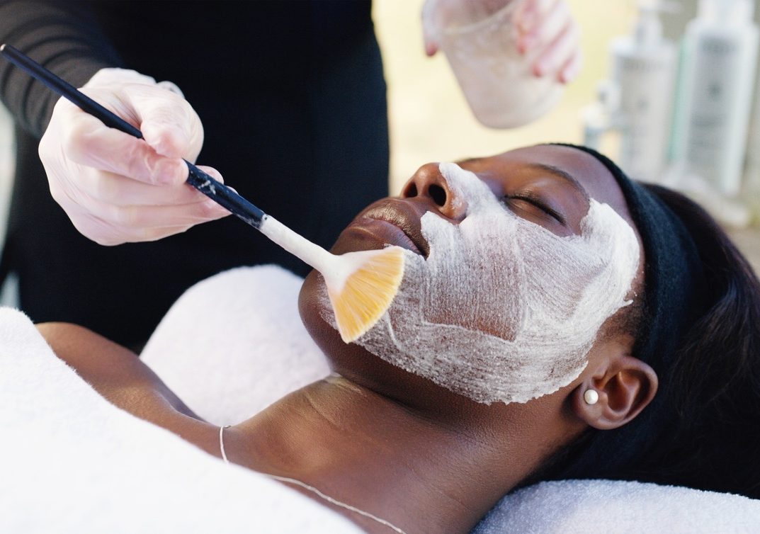 Woman receiving facial mask treatment at a spa