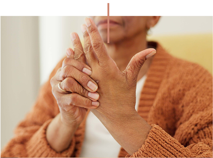Woman massaging her hand and fingers in a close-up wellness pose