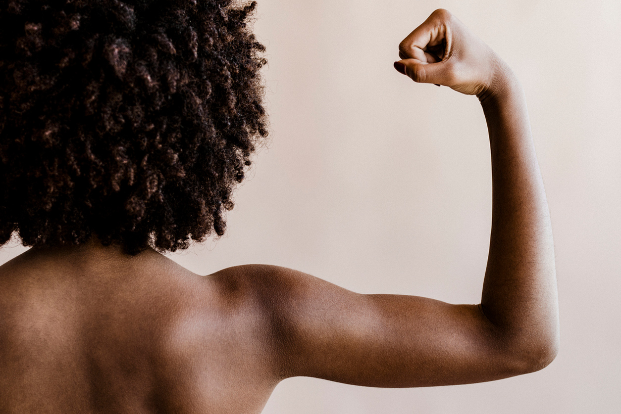 Back view of a woman flexing her arm and showing her shoulder muscles